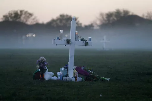 In this Feb. 17, 2018, file photo, an early morning fog rises where 17 memorial crosses were placed for the 17 students and faculty killed in the shooting at Marjory Stoneman Douglas High School in Parkland, Fla. The 12 jurors and 10 alternates chosen this past week to decide whether Cruz is executed will be exposed to horrific images and emotional testimony, but must deal with any mental anguish alone. (AP Photo/Gerald Herbert, File)