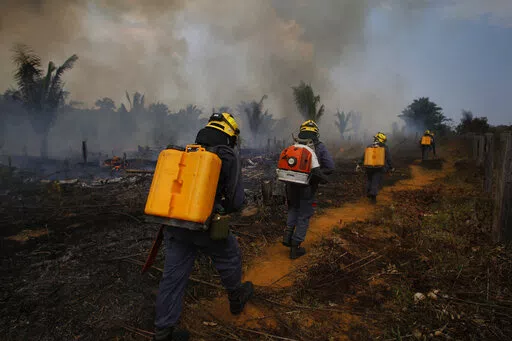 Fire brigade members walk in to a burnt area in Apui, Amazonas state, Brazil, Sept. 21, 2022. Despite the smoke clogging the air of entire Amazon cities, state elections have largely ignored environmental issues. Far-right President Jair Bolsonaro is seeking a second four-year term against leftist Luiz Inácio Lula da Silva, who ruled Brazil between 2003 and 2010. (AP Photo/Edmar Barros, File)
