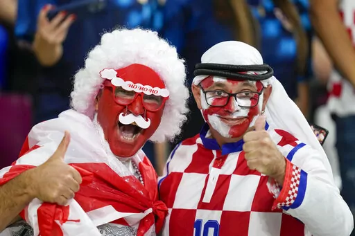 Croatia and Canada fans cheer ahead of the World Cup group F soccer match between Croatia and Canada, at the Khalifa International Stadium in Doha, Qatar, Sunday, Nov. 27, 2022. At a World Cup that has become a political lightning rod, it comes as no surprise that soccer fans’ sartorial style has sparked controversy. At the first World Cup in the Middle East, fans from around the world have refashioned traditional Gulf Arab headdresses and thobes. (AP Photo/Darko Vojinovic, File)