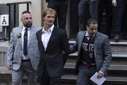 Daniel Penny, center, is walked by New York Police Department detectives out of the 5th Precinct, May 12, 2023, in New York. Penny, the man charged with manslaughter for putting an agitated New York City subway rider in a fatal chokehold, has been indicted by a grand jury, an expected procedural step that will allow the criminal case to continue. (AP Photo/Jeenah Moon, File)