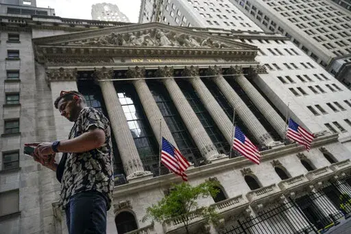 Pedestrians walk past the New York Stock Exchange, on July 8, 2022, in New York.  Stocks are opening lower on Wall Street Wednesday, Aug. 17,  as traders absorb some discouraging news about how much Americans are spending. (AP Photo/John Minchillo, file)