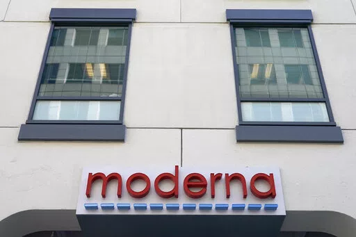 In this Dec. 15, 2020, file photo, a sign for Moderna, Inc. hangs on its headquarters in Cambridge, Mass.  Moderna's experimental COVID-19 vaccine that combines its original shot with protection against the omicron variant appears to work, the company announced Wednesday, June 8, 2022.  COVID-19 vaccine makers are studying updated boosters that might be offered in the fall to better protect people against future coronavirus surges.(AP Photo/Elise Amendola, File)