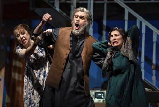 Maureen McKay, left, who portrays Laila, John Moore, who portrays Rasheed, and Karin Mushegain, who portrays Mariam, perform in a dress rehearsal for the opera "A Thousand Splendid Suns," in Seattle, on Wednesday, Feb. 22, 2023. Making its world debut Saturday, Feb. 25, 2023, it is based on a popular novel by Kabul-born author Khaled Hosseini that explores the inner worlds of Mariam and Laila over decades of Afghan history, some with stark parallels to the present. (AP Photo/Stephen Brashear)