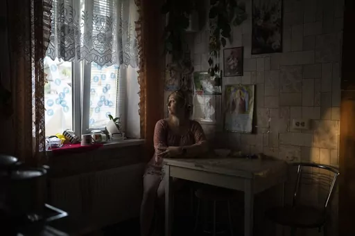 Natalia Rosolova poses for a portrait inside her house in Kupiansk-Vuzlovyi, Ukraine, Wednesday, Aug. 23, 2023. Residents of the war-ravaged settlement close to the northeast frontline are ignoring calls from Ukrainian authorities to evacuate as the fighting inches closer. (AP Photo/Bram Janssen)