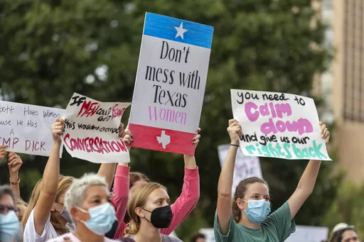 FILE -People take part in the Women's March ATX rally, Saturday, Oct., 2, 2021 in at the Texas State Capitol in Austin, Texas. Texas has released data showing a marked drop in abortions at clinics in the state in the first month under the nation's strictest abortion law, but that only tells part of the story, Friday, Feb. 25, 2022. (AP Photo/Stephen Spillman, File)