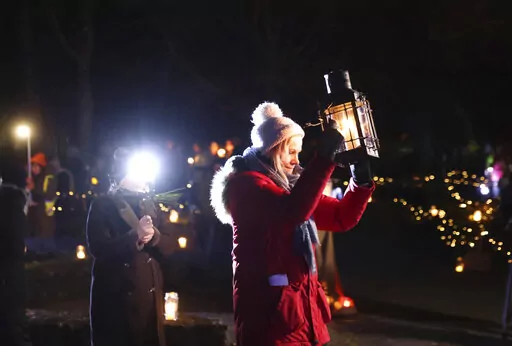 People participate in a candlelight pilgrimage walk which makes its way past an ancient well associated with St Brigid to the Solas Bhride Centre in Kildare, Ireland, Tuesday, Jan. 31, 2023. (AP Photo/Peter Morrison)