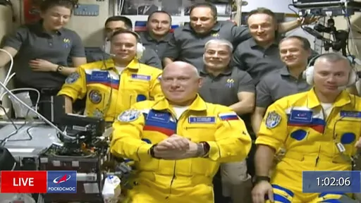 In this frame grab from video provided by Roscosmos, Russian cosmonauts Sergey Korsakov, Oleg Artemyev and Denis Matveyev are seen during a welcome ceremony after arriving at the International Space Station, Friday, March 18, 2022, the first new faces in space since the start of Russia’s war in Ukraine. The crew emerged from the Soyuz capsule wearing yellow flight suits with blue stripes, the colors of the Ukrainian flag. (Roscosmos via AP)