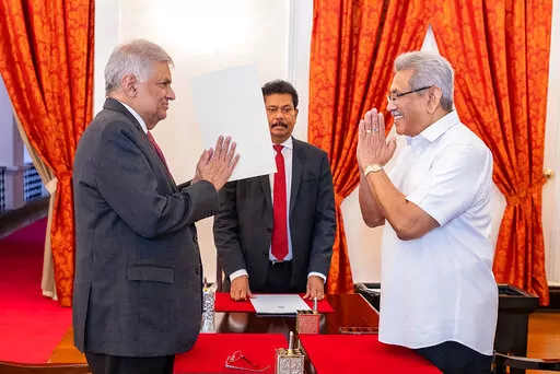 FILE- In this photograph provided by the Sri Lankan President's Office, President Gotabaya Rajapaksa, right, greets prime minister Ranil Wickremesinghe during the latter's oath taking ceremony as the new finance minister in Colombo, Sri Lanka, May 25, 2022. Both men Saturday said they would resign, after the country’s most chaotic day in months of political turmoil, with protesters storming both officials’ homes and setting fire to one of the buildings in a rage over the nation’s severe ec