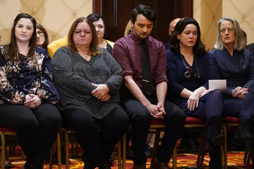 Families of the victims of the Newtown shooting and attorneys listen during a news conference in Trumbull, Conn., Tuesday, Feb. 15, 2022. The families of nine victims of the Sandy Hook Elementary School shooting have agreed to a $73 million settlement of a lawsuit against the maker of the rifle used to kill 20 first graders and six educators in 2012, their attorney said Tuesday. (AP Photo/Seth Wenig)