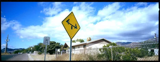 A "playground ahead" warning stands by the side of a road on the outskirts of Bisbee, Ariz., Oct. 26, 2021. Bisbee was home to Paul and Leizza Adams, and their six children, before Paul and Leizza were charged with child sexual abuse. (AP Photo/Dario Lopez-Mills)