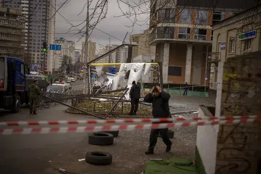 Police officers inspect area after an apparent Russian strike in Kyiv Ukraine, Thursday, Feb. 24, 2022. Russian President Vladimir Putin on Thursday announced a military operation in Ukraine and warned other countries that any attempt to interfere with the Russian action would lead to "consequences you have never seen." (AP Photo/Emilio Morenatti)