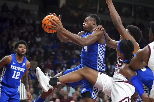 Kentucky forward Oscar Tshiebwe grabs a rebound against South Carolina forward Ta'Quan Woodley, right, during the second half of an NCAA college basketball game Tuesday, Feb. 8, 2022, in Columbia, S.C. Kentucky won 86-76. (AP Photo/Sean Rayford)
