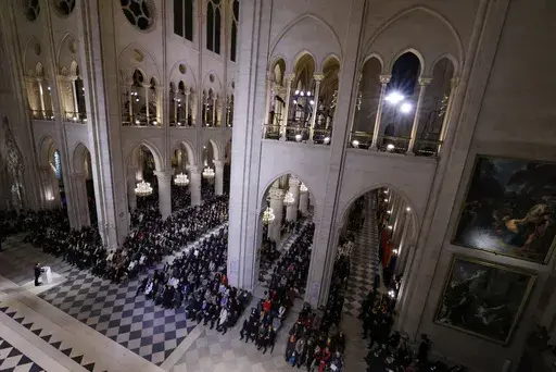 French President Emmanuel Macron, left, speaks in Notre Dame Cathedral as France's iconic cathedral is formally reopening its doors for the first time since a devastating fire nearly destroyed the 861-year-old landmark in 2019, Saturday Dec.7, 2024 in Paris ( Ludovic Marin, Pool via AP)