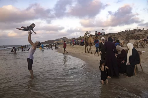 Palestinians enjoy the day on the beach in the Mediterranean Sea during a heat wave in Gaza City, Sunday, July 23, 2023. (AP Photo/Fatima Shbair)