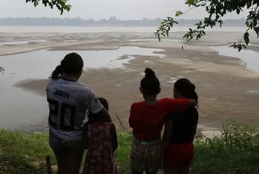 Residents look out at the Madeira River, a tributary of the Amazon River amid a drought in Humaita, Amazonas state, Brazil, Sept. 7, 2024. (AP Photo/Edmar Barros, File)