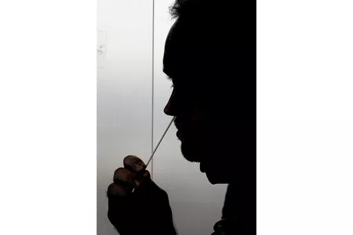 FILE - A rapid COVID-19 test is taken, Wednesday, Nov. 18, 2020, in Salt Lake City. President Joe Biden says the federal government will buy half a billion COVID-19 rapid test kits and distribute them free of charge to people to use at home. Delivery of the first batch of the 500 million tests isn't expected until early January 2022. (AP Photo/Rick Bowmer, File)