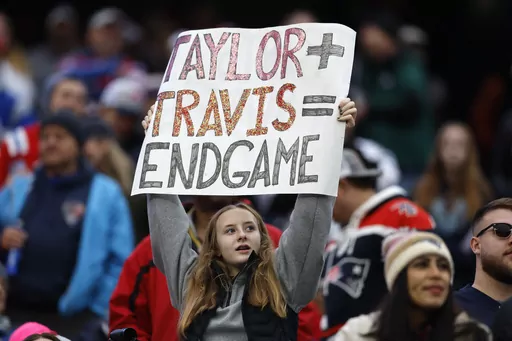 A fan displays a sign that calls attention to Taylor Swift and Kansas City Chiefs tight end Travis Kelce during the second half of an NFL football game between the Chiefs and the New England Patriots, Sunday, Dec. 17, 2023, in Foxborough, Mass. (AP Photo/Michael Dwyer, File)