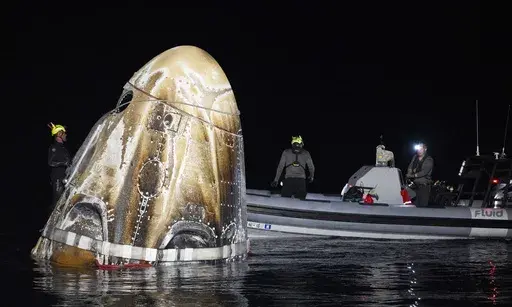 This photo provided by NASA shows support teams work around the SpaceX Dragon Endeavour spacecraft shortly after it landed, in the Gulf of Mexico off the coast of Pensacola, Florida, Friday, Oct. 25, 2024. (NASA/Joel Kowsky via AP)