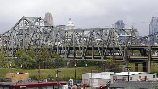 Traffic on the Brent Spence Bridge passes in front of the Cincinnati skyline while crossing the Ohio River to and from Covington, Ky., Oct. 7, 2014. According to a recent announcement by Kentucky and Ohio they will receive more than $1.63 billion in federal grants to help build a new Ohio River bridge near Cincinnati and improve the existing overloaded span there, a heavily used freight route linking the Midwest and the South. (AP Photo/Al Behrman, File)