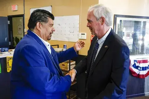 Wisconsin Republican U.S. Senate candidate Ron Johnson and Pastor Marty Calderon shake hands at a local Republican election office in Milwaukee, on Saturday, Oct. 8, 2022. In two decades of street outreach on Milwaukee’s south side, Calderon has offered Bible study, gang prevention, a safe place to stay for those battling addiction, and help getting jobs for those newly released from prison. But as he’s watched rising crime threaten those efforts to “clean up” his impoverished neighborho
