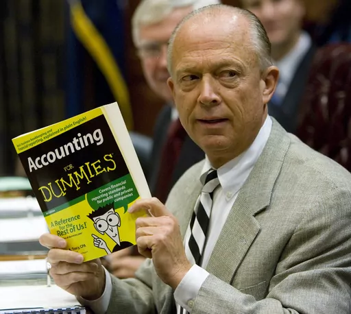South Carolina Comptroller General Richard Eckstrom holds up a book he wanted to present to his new Chief of Staff James Holly during his introduction at the Budget and Control Board meeting, Aug. 13, 2009, in Columbia, S.C. Pressure is mounting for Eckstrom after a $3.5B accounting error. (AP Photo/Mary Ann Chastain, File)