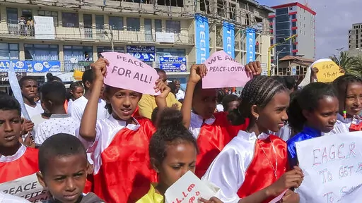 Children from a local martial arts and fitness center hold peace signs at a street carnival organized by the Tigray Development Association in support of the recent peace deal agreed between the Ethiopian federal government and Tigray forces, in Mekele, the capital of the Tigray region, in northern Ethiopia on Saturday, Nov. 26, 2022. (AP Photo)