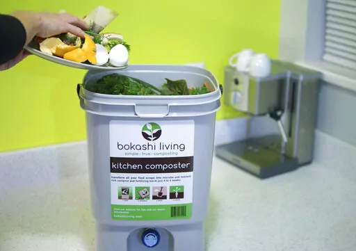 This image provided by Bokashi Living shows kitchen scraps being added to a bokashi composting bucket. (bokashiliving.com via AP)