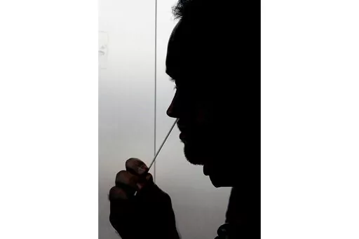 A rapid COVID-19 test is taken, Wednesday, Nov. 18, 2020, in Salt Lake City. President Joe Biden says the federal government will buy half a billion COVID-19 rapid test kits and distribute them free of charge to people to use at home. Delivery of the first batch of the 500 million tests isn't expected until early January 2022. (AP Photo/Rick Bowmer, File)